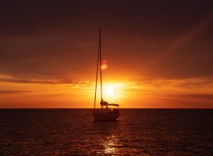 Aerial view from drone on boat shipping in sea, sunset. Yachting with a dramatic sunset as backdrop