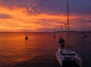 Aerial view from drone on boats shipping in sea, sunset. Yachting with a dramatic sunset as backdrop